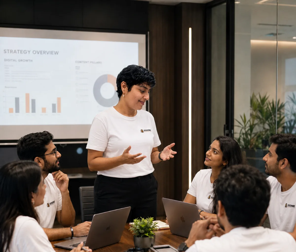 Sangeetha S Abishek presenting a strategy overview to the SODME team around a boardroom table.