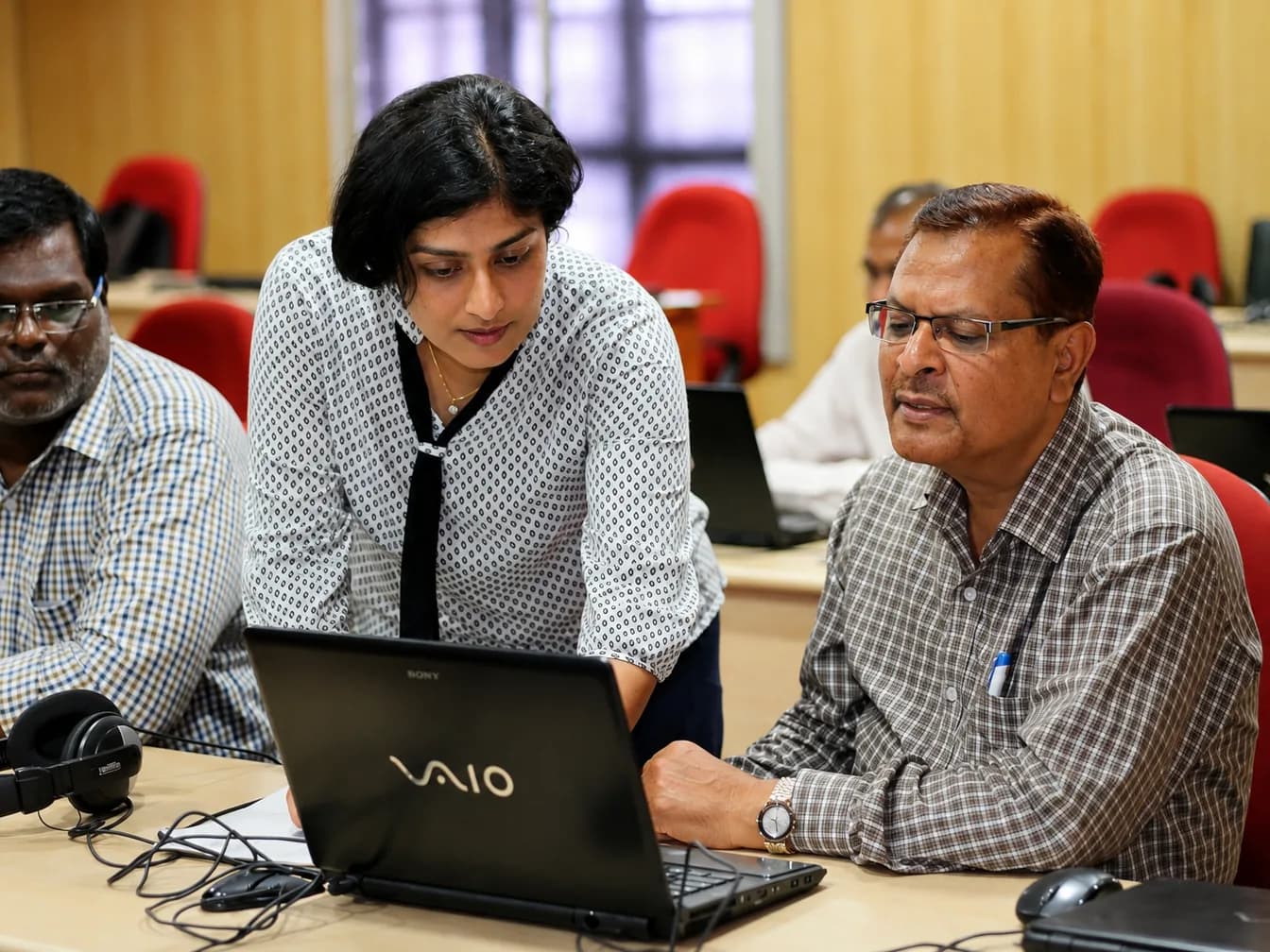 Sangeetha S Abishek working through something on a laptop with a participant during a hands-on training session.